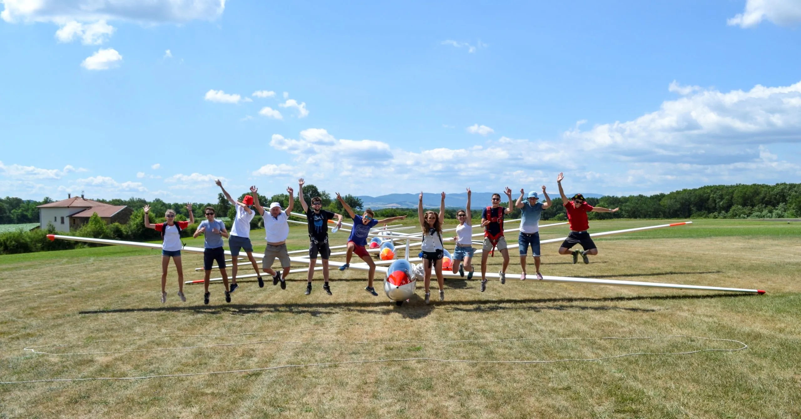 Membres du club sautant de joie devant les planeurs alignés sur la piste